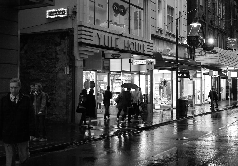 Melb_P1010492.jpg - Grumpy man decided to walk in to my shot. 25mm f/2.8 ISO 1600.1/125th sec at  night in the rain. No PS except conversion to monochrome.